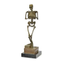 Bronzen skeletbeeld met handen voor de borst op zwarte sokkel