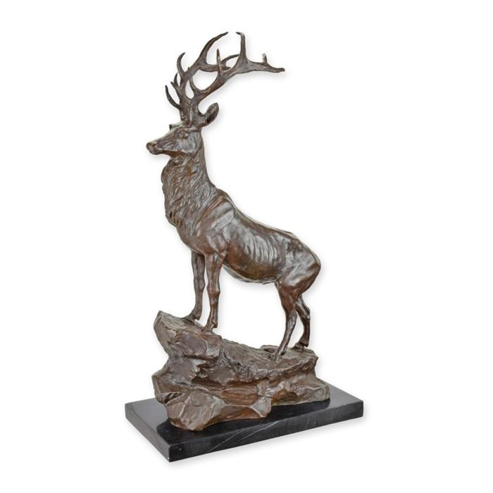 Bronzen sculptuur van hert met vertakt gewei op rots en donkere sokkel